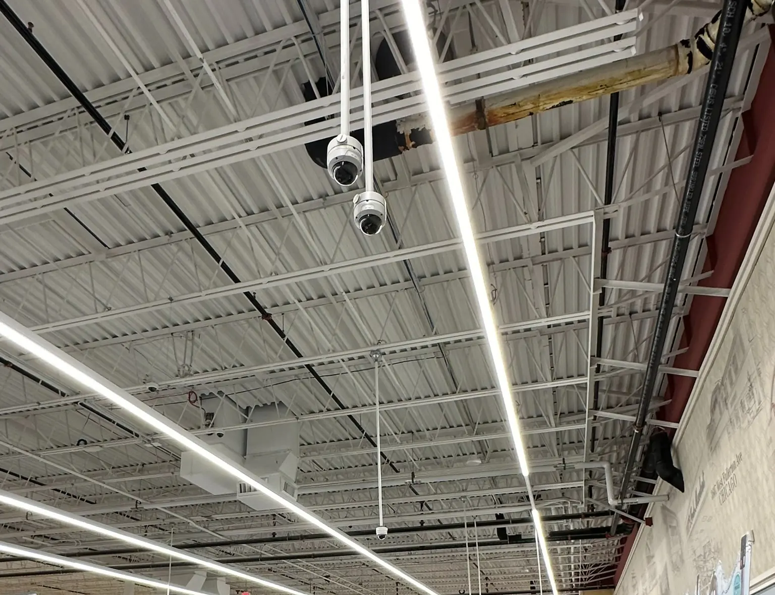 Overhead security cameras installed above a commercial retail checkout area