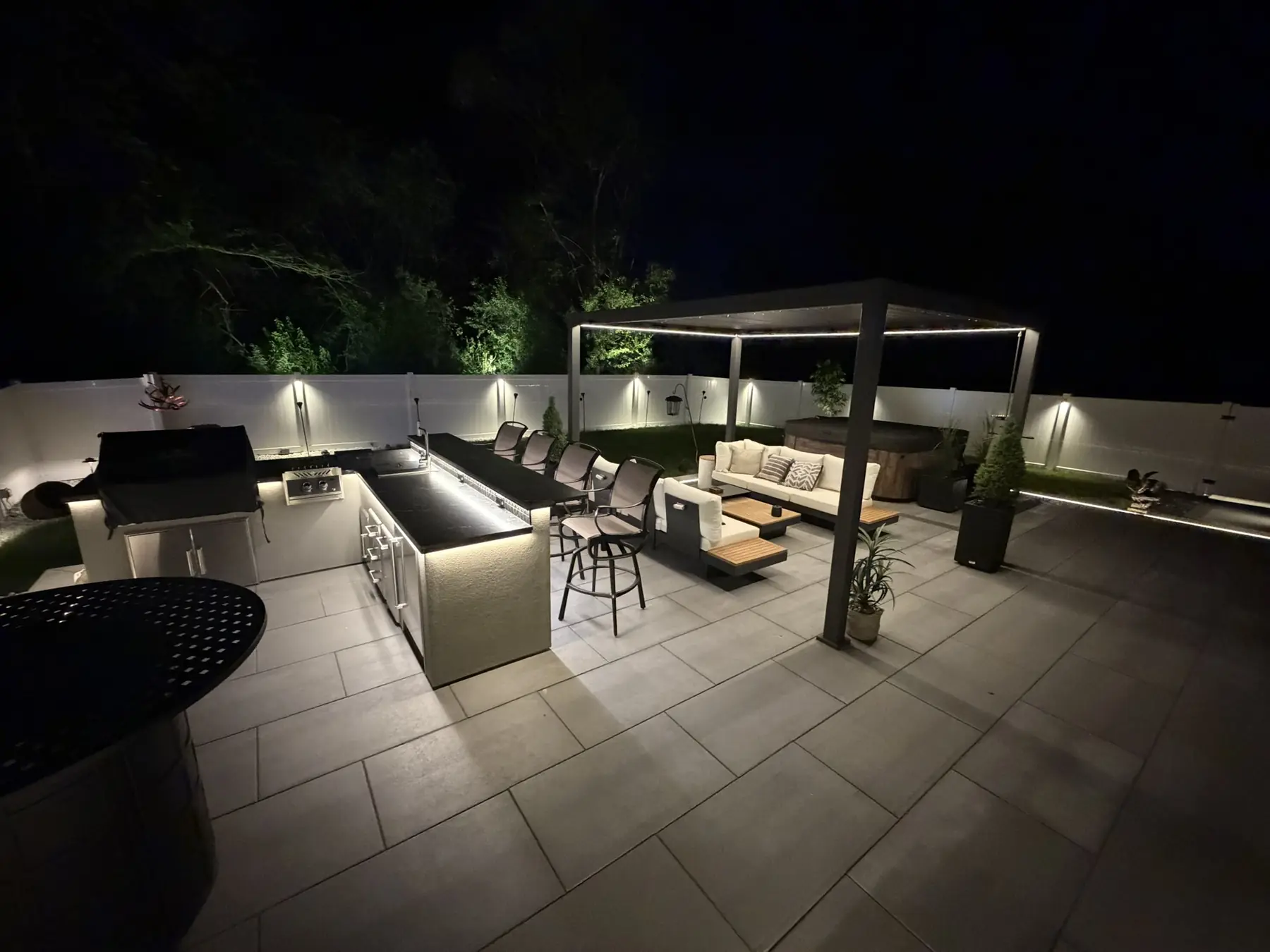 Outdoor living space illuminated with architectural and landscape lighting at night